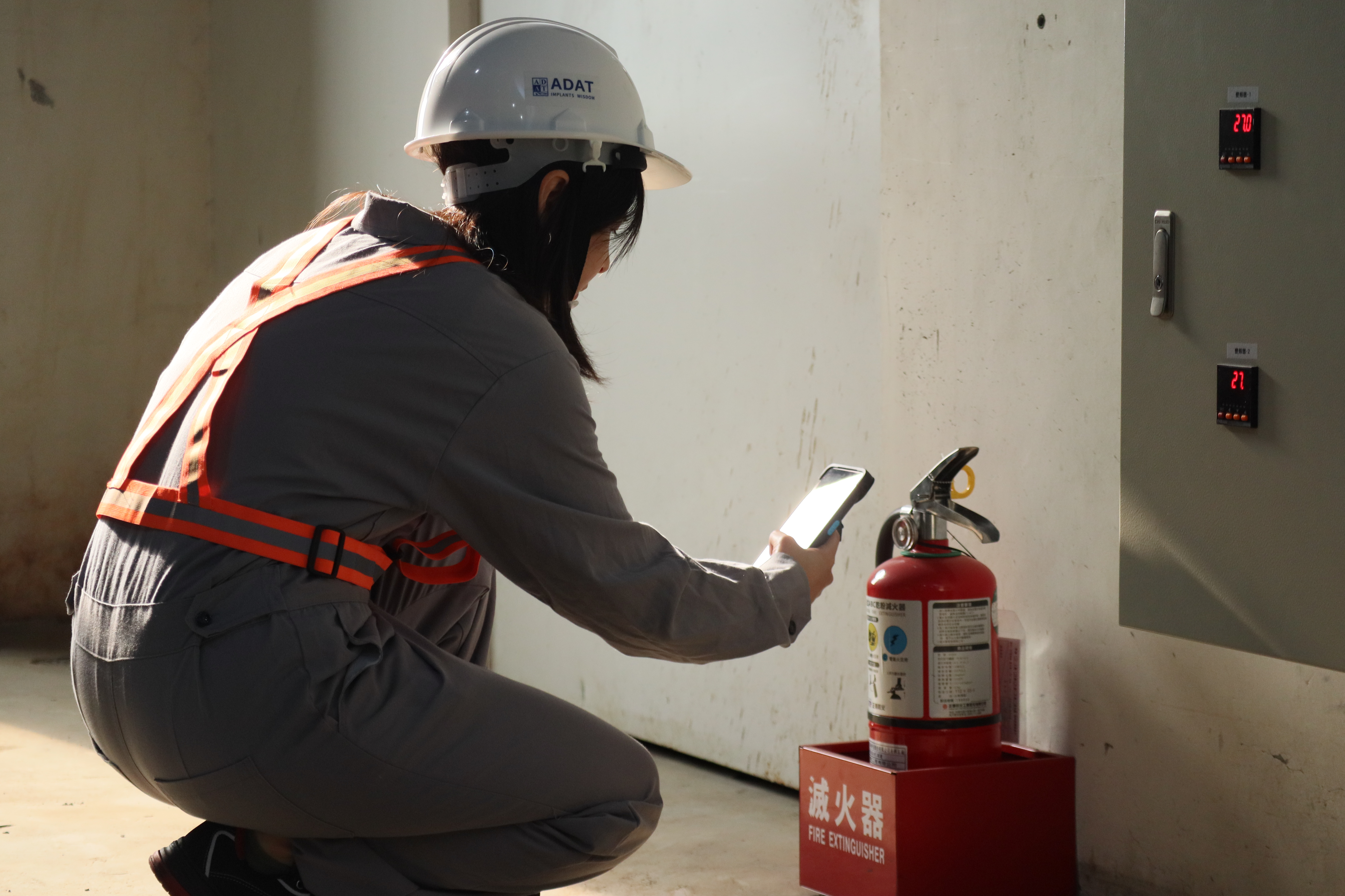 Inspector recording fire extinguisher safety check data
